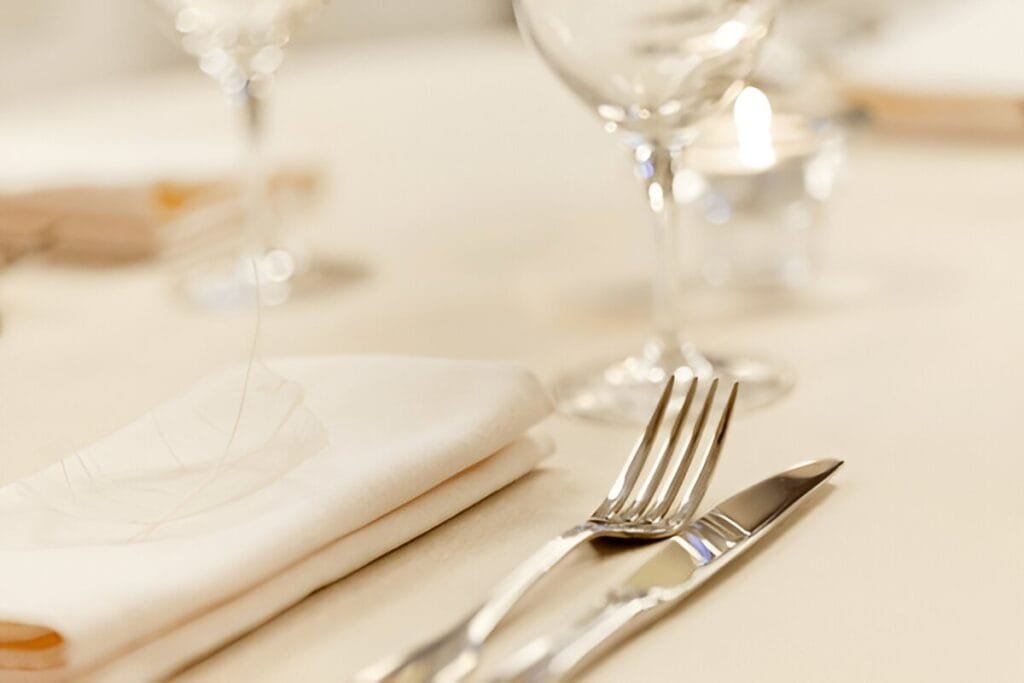 A representation of Flatware Reviews- knife and fork on a table beside a napkin