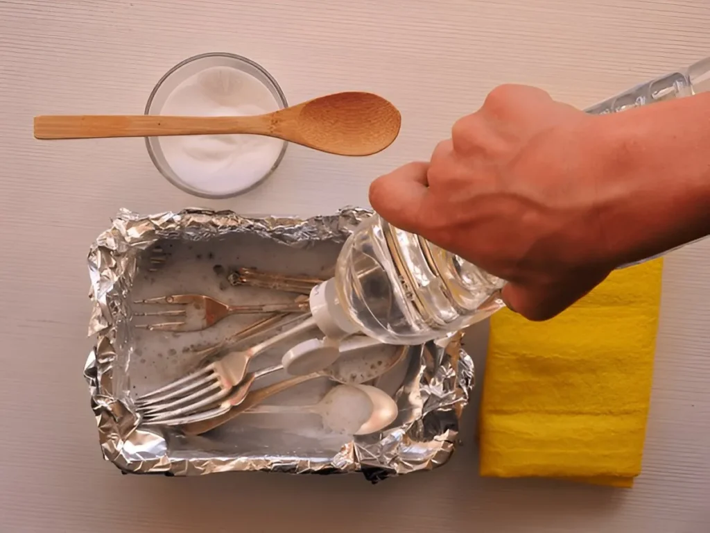 Showing how to clean silverware with baking soda and aluminium foil, with water being added