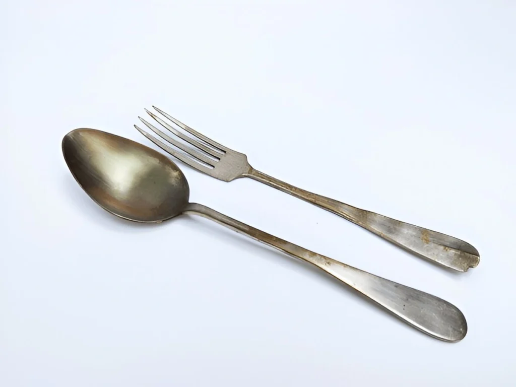 A pair of tarnished fork and spoon displayed to show how to clean silverware