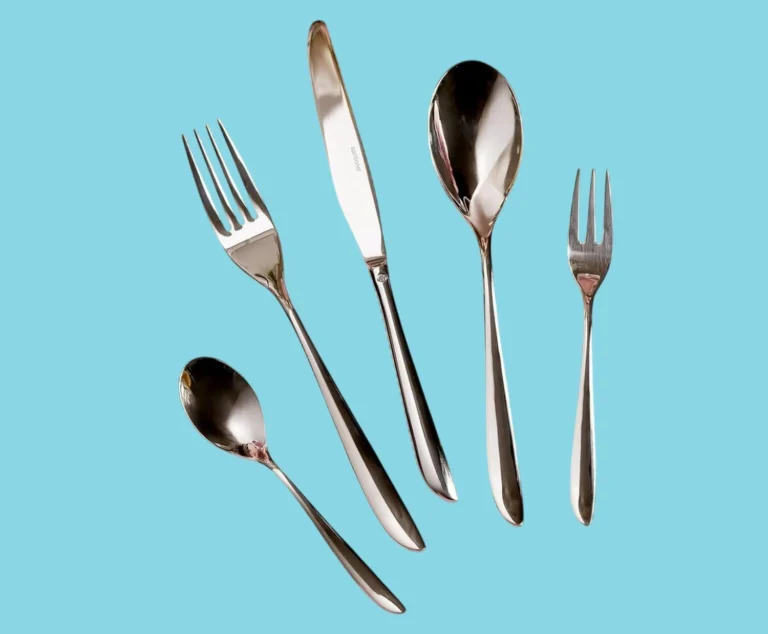 A 5 piece Sambonet flatware place setting on a blue background