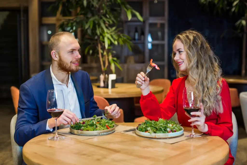 A man and a woman using hammered cutlery on a table