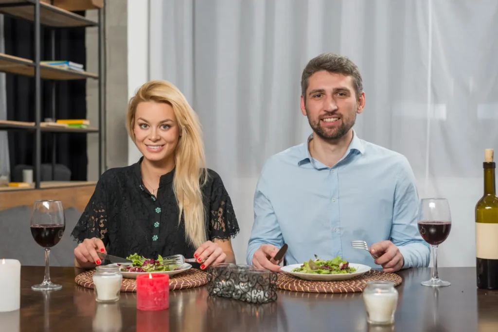 A man and a woman using hammered silverware on a table