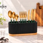 A HouseJoy best utensil caddy holding kinves, forks and spoons on a kitchen counter