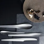Georg Jensen silverware's Arne Jacobsen place setting arranged on a minimalist Scandinavian dining table