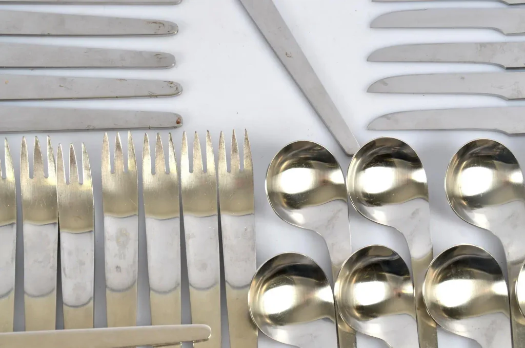 Side-by-side comparison of minimalist AJ cutlery with decorative traditional silverware patterns